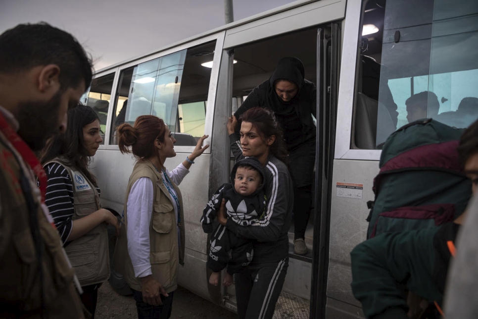 Personal de ACNUR y de instituciones socias prestan ayuda a las personas refugiadas sirias que llegan en autobús hasta el campamento de Bardarash en Duhok (Iraq). 