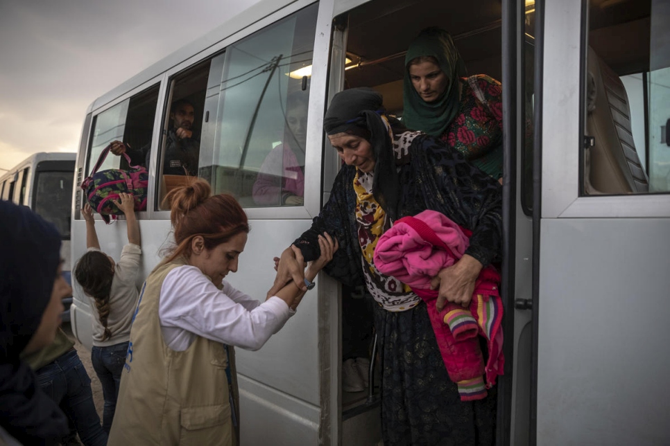 ACNUR y sus socios ayudan a las personas refugiadas sirias que llegan en un convoy de autobuses al campamento de Bardarash en Duhok, Irak.