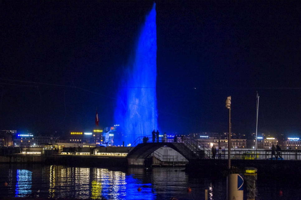 Vista del famoso Jet d'Eau, símbolo de la ciudad de Ginebra, iluminado de azul con ocasión del Foro Mundial sobre los Refugiados.