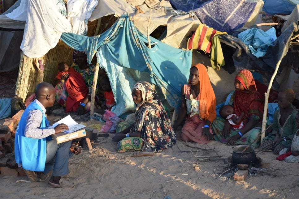 Un trabajador de ACNUR, la Agencia de la ONU para los Refugiados, habla con varias mujeres sudanesas recién llegadas como refugiadas a Adré, en Chad.