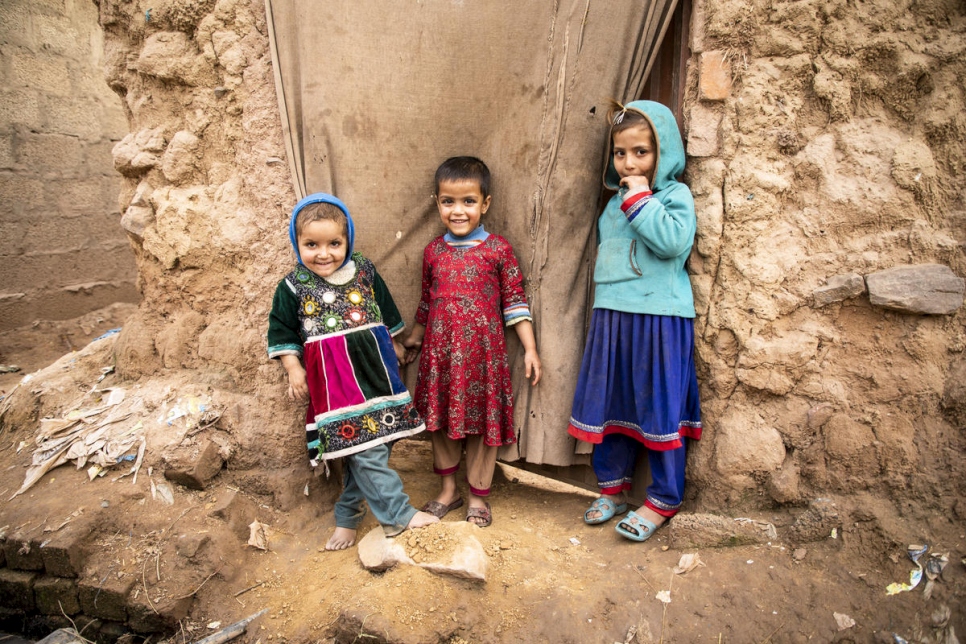 Niños afganos ante la puerta de una casa en un asentamiento en Islamabad, Pakistán, que acoge a unos 3.000 refugiados afganos.