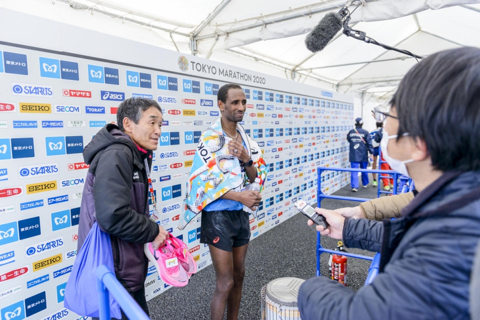 El atleta refugiado Yonas Kinde es entrevistado después de terminar el Maratón de Tokio 2020.