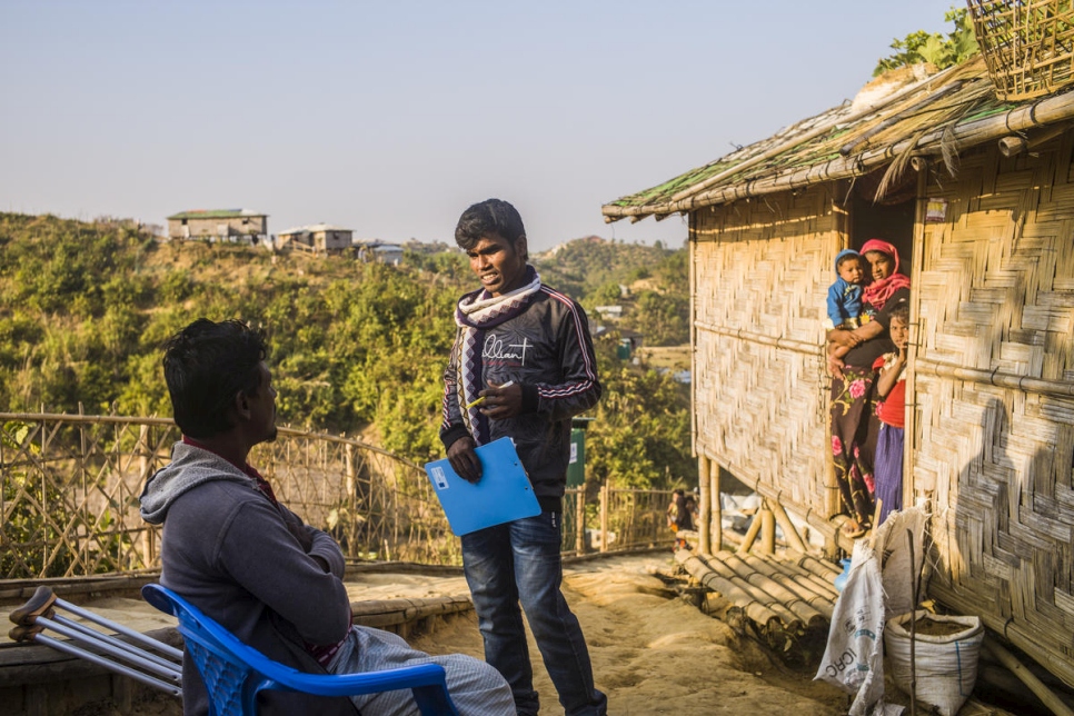 Los voluntarios de acercamiento comunitario hacen un trabajo fundamental informando a los refugiados que viven en los campamentos de Bangladesh. Un voluntario visita una familia en el campamento de refugiados de Charkmakul, el 26 de enero de 2020.