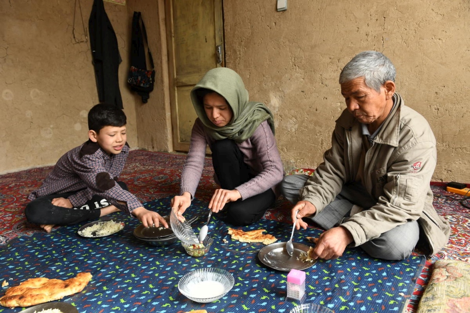 Kobra Yusufy, afgana de 27 años, almuerza con su hermano Mahdi, de 11 años, y su padre Mohammad, de 56 años, en su sala de estar en Kabul. 