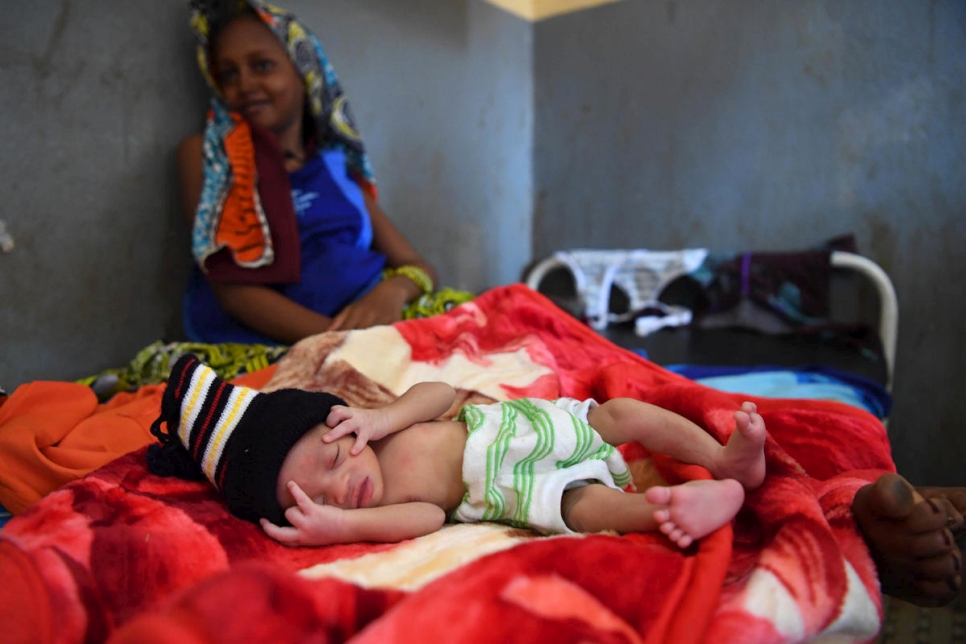 En el centro de salud de Mbilé, la madre centroafricana Rabiatou se sienta cerca de su bebé recién nacido, que llegó al mundo pesando solo 1,9 kilogramos, pero gracias al método madre cangura ha alcanzado un peso estable. 
