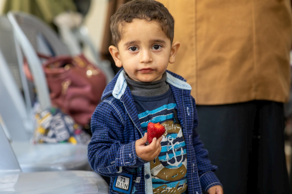 Mohammad, un refugiado sirio de cuatro años, come una fresa mientras su madre participa en un curso de cocina en el centro comunitario de Nuzha, que cuenta con el apoyo de ACNUR, en el este de Amán, en Jordania.