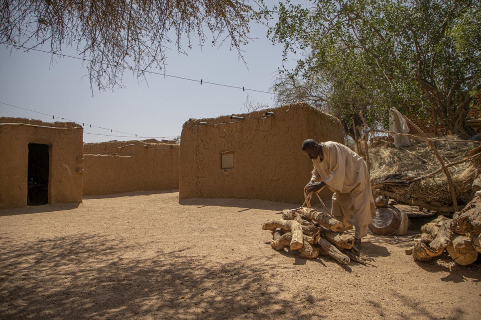 Ahmed Ishag Babiker, de 54 años, apila leña en su alojamiento en Kabkabiya, en el norte de Darfur, Sudán. Él y su familia se desplazaron cuando grupos armados atacaron su aldea en Wadi Bare en 2004. 