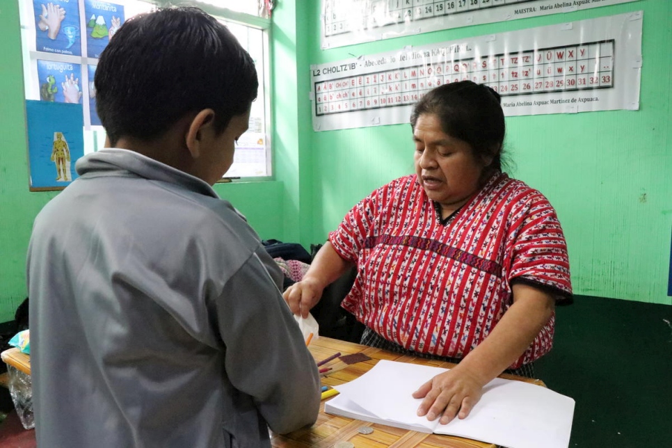 Isai* (de chaqueta gris), un solicitante de asilo nicaragüense de ocho años, con su maestra de tercer grado antes de que cerrara su escuela a las afueras de la ciudad de Guatemala. 