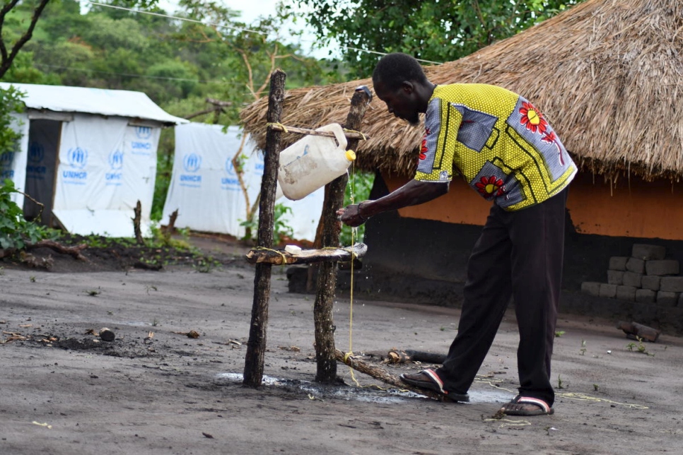 Chris, un refugiado sursudanés, utiliza un lavamanos que hizo con madera, un viejo bidón y una cuerda en el asentamiento de Bele, República Democrática del Congo. 