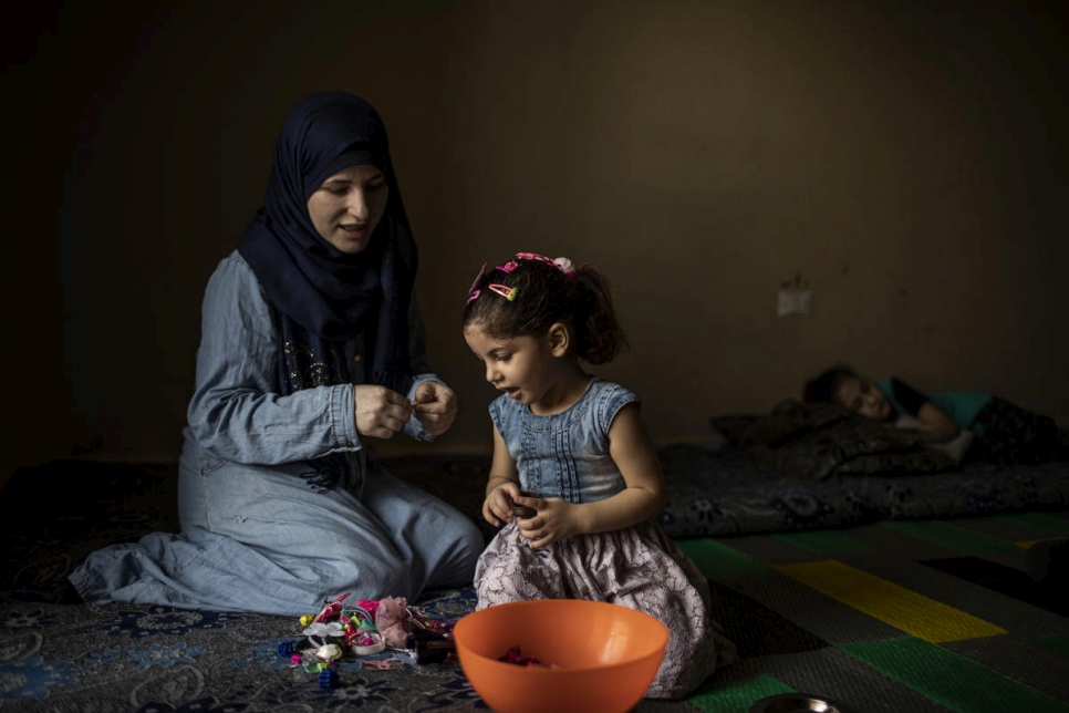 La refugiada siria Wafaa sujeta el cabello de su hija Yasmine en su casa en Barja, Líbano. 