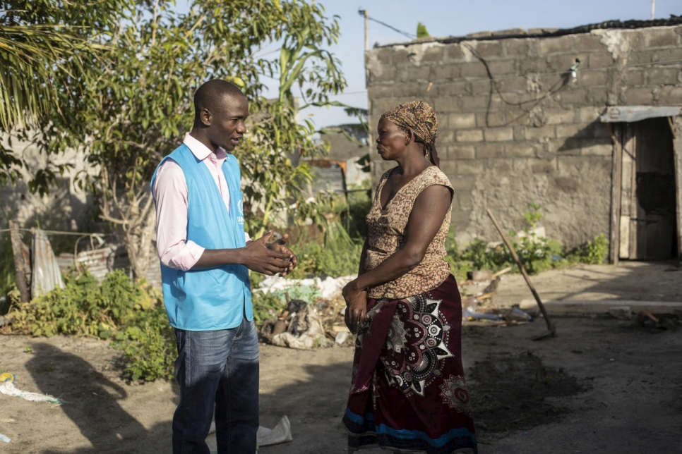 Luis Jose Faife habla con una mujer que sobrevivió al ciclón Idai en Beira, Mozambique. El techo de su casa, detrás de ella, voló durante el ciclón. 