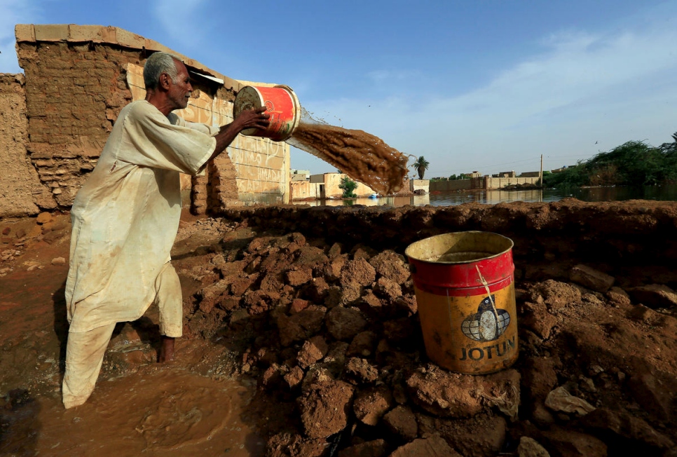 
Un residente retira cubos de agua de las inundaciones del Nilo en Al-Ikmayr, una área de Omdurmán en Jartum. 
