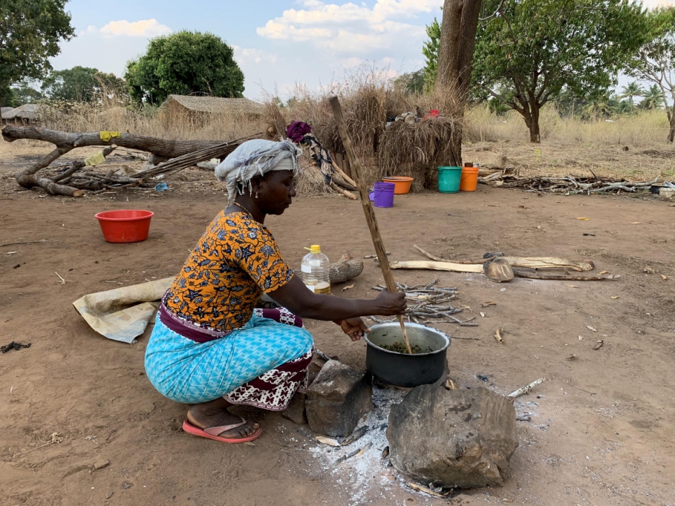 Joaquina * cocina para su familia y parientes fuera de la casa de su hermano en Montepuez después de huir de ataques violentos en el norte de Mozambique. 