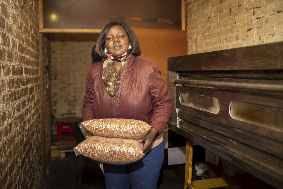 Grace, refugiada congoleña de 43 años, carga bolsas de maní tostado en su negocio en Pretoria, Sudáfrica.