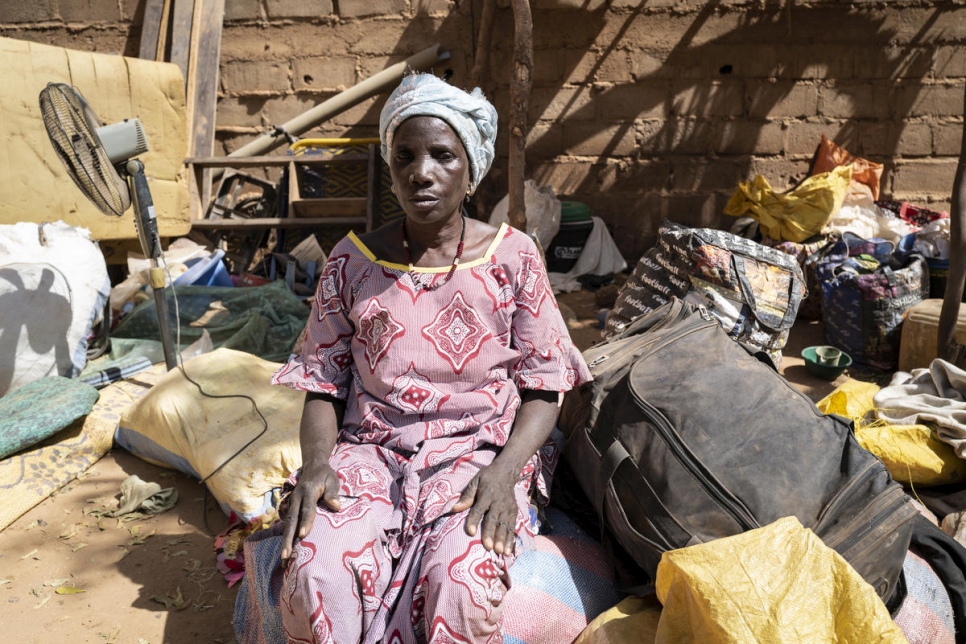 Una mujer desplazada interna burkinesa está sentada entre sus pertenencias en Kaya, Burkina Faso, en febrero de 2020. 