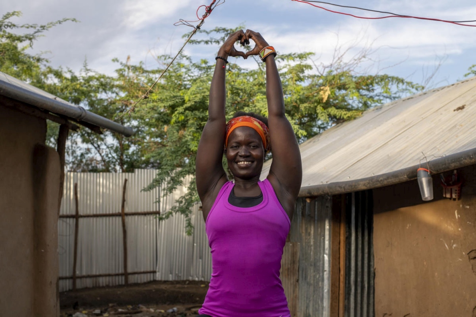 Rita Brown, refugiada ugandesa y profesora de yoga, hace una postura fuera de su alojamiento en el campamento de refugiados de Kakuma, en Kenia. Ella da clases en línea que ayudan a personas refugiadas y otros participantes a lidiar con el estrés.