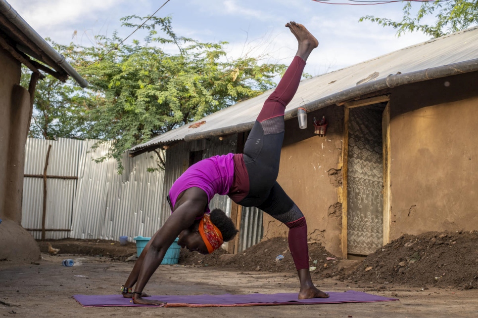 Rita Brown, una refugiada e instructora de yoga de Uganda, hace una postura de yoga fuera de su alojamiento en el campamento de Kakuma, Kenia. 