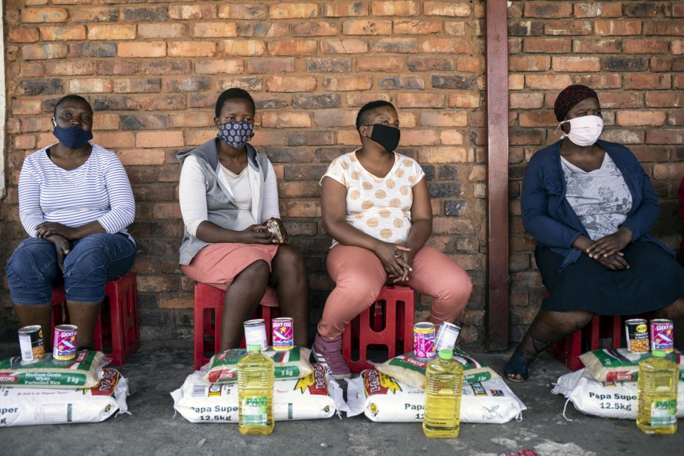 Las mujeres sudafricanas vulnerables reciben paquetes de alimentos que incluyen harina, arroz, frijoles y aceite de miembros de la comunidad empresarial somalí en Pretoria, Sudáfrica. 