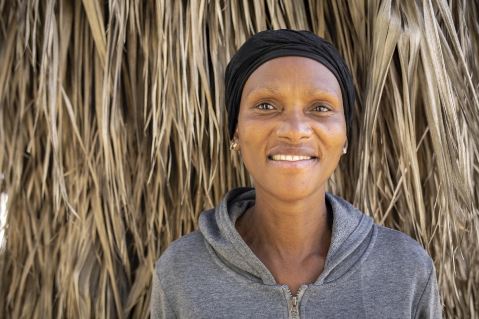 Regina, una beneficiaria sudafricana de paquetes de alimentos distribuidos por la comunidad empresarial somalí, posa en Pretoria, Sudáfrica. 