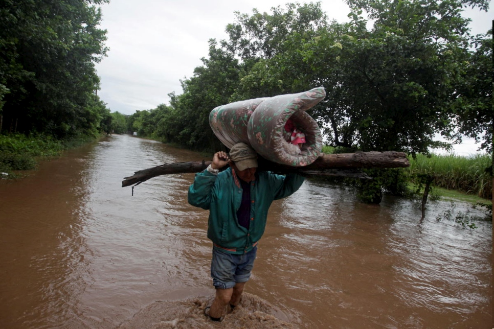 Un hombre lleva sus pertenencias por un camino inundado tras el paso del huracán Iota, en Marcovia, Honduras, el 18 de noviembre de 2020.