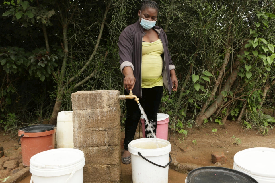 Josephine Mbayo llena una cubeta de agua mediante una de las llaves recién instaladas en el campamento de refugiados de Tongogara.