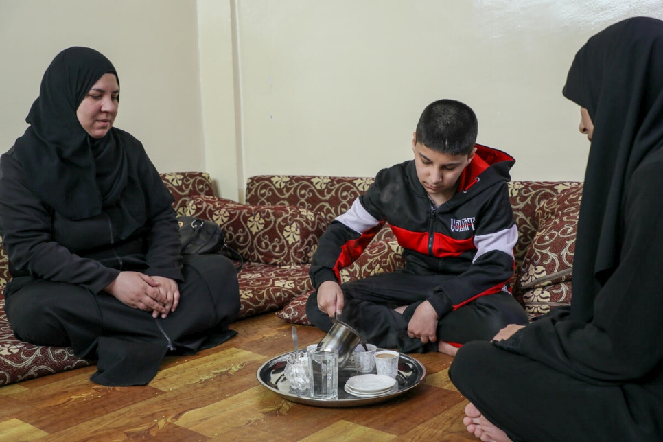 Ali de 12 años, sirve café para su madre Jameela (izquierda) y su tía Huda (derecha) en su casa en Ammán, Jordania.