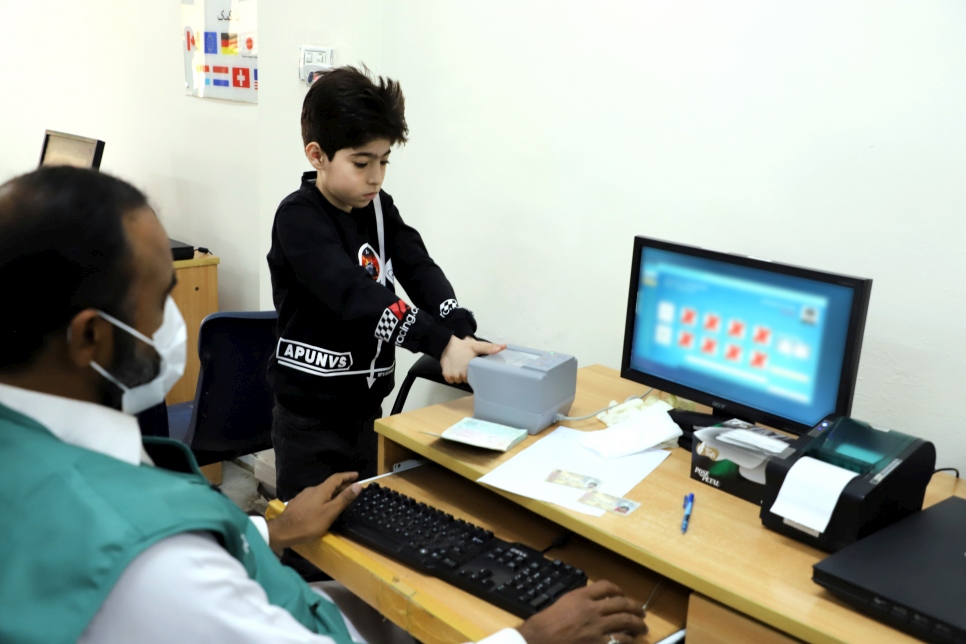 Niño afgano refugiado proporciona sus datos biométricos para la emisión de una credencial inteligente en Rawalpindi, Pakistán.