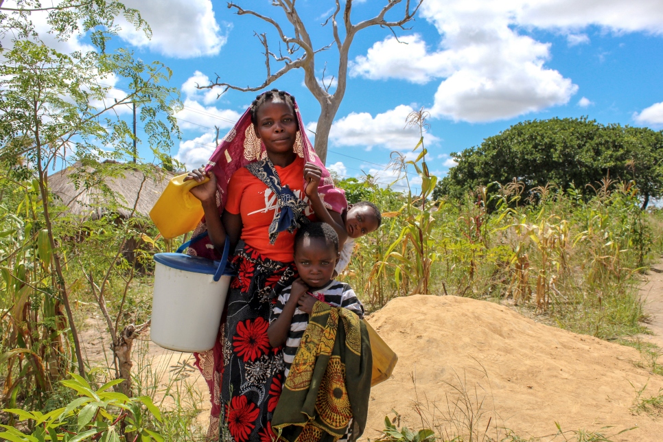 Una madre desplazada y sus hijos recolectan agua en un asentamiento para personas desplazadas internas en el distrito de Montepuez, Cabo Delgado, Mozambique.