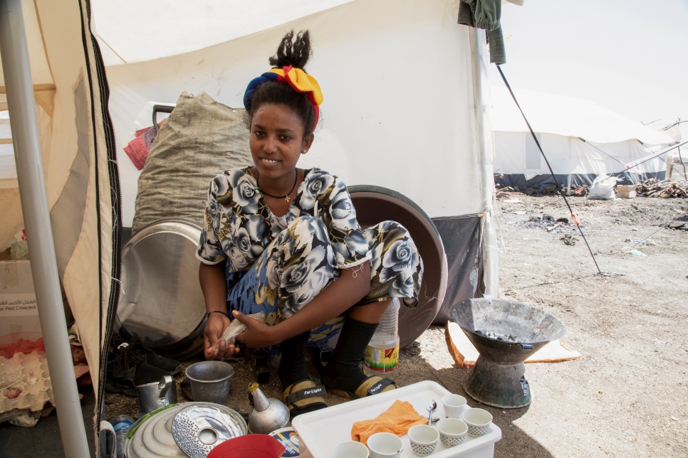 Anna* prepara café tradicional en el área de la cocina de su tienda en el campamento de refugiados de Tunaydbah, en el este de Sudán.