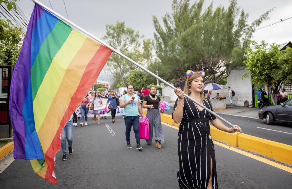 Bianka Rodríguez, activista LGBTIQ+, marcha con la bandera del arcoíris en un desfile por los derechos de las personas trans en San Salvador, El Salvador.