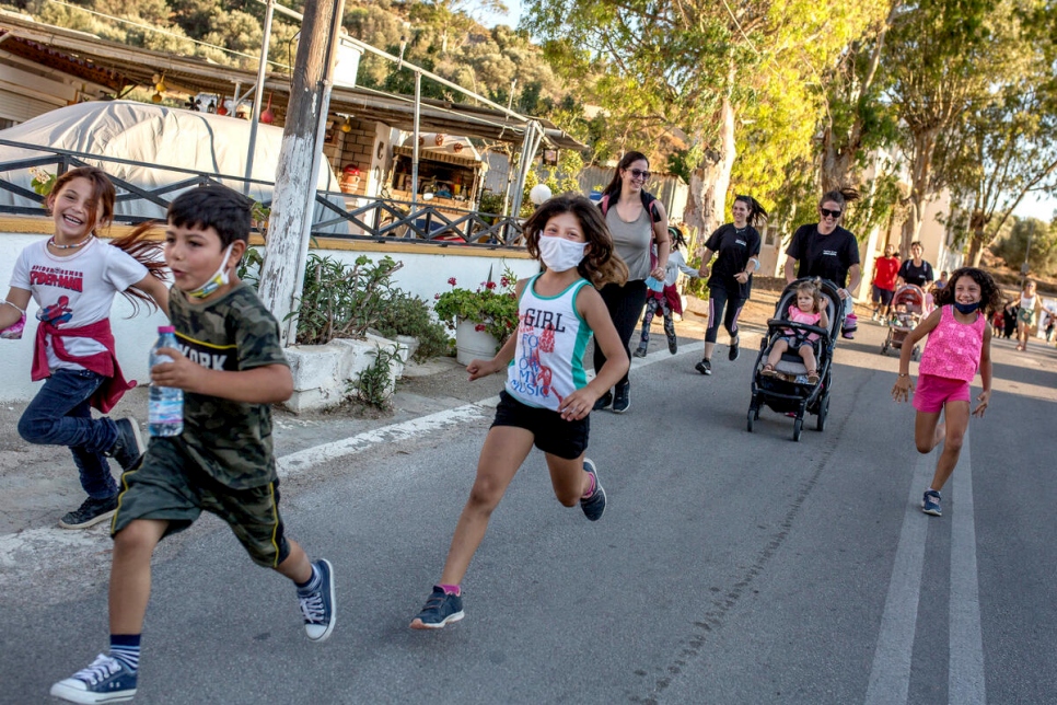 Niñas, niños y adultos corren un maratón de corta distancia durante el evento del Día Mundial del Refugiado celebrado en la isla griega de Leros. 