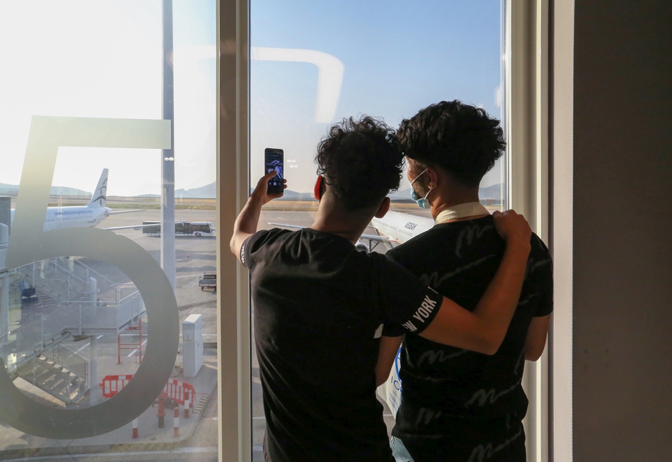 Dos niños refugiados se toman una selfie en el aeropuerto de Atenas antes de su vuelo de reubicación a Francia.