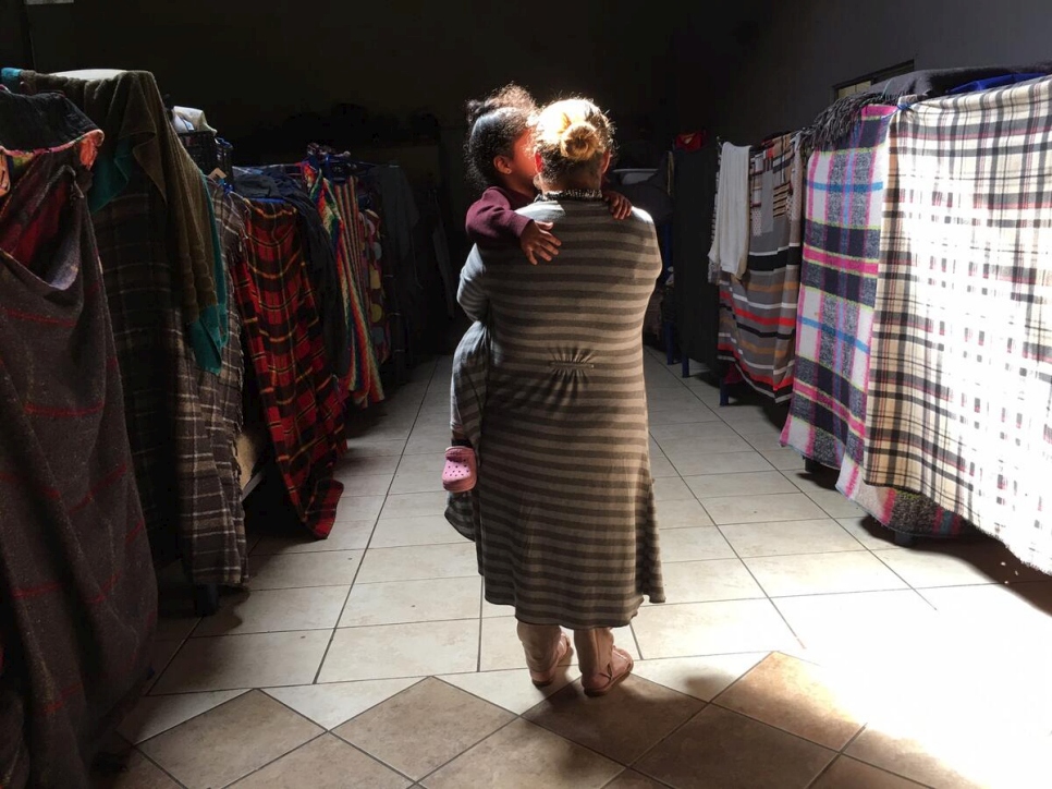 Ana, una madre hondureña de 27 años, sostiene a su hija de tres años en brazos en un alojamiento improvisado para solicitantes de asilo en Tijuana, México.