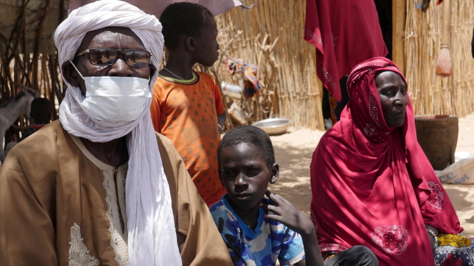 Alimi Abali (izquierda) sentado frente a su hogar en el campamento de Forkoloum, cerca del lago Chad. 