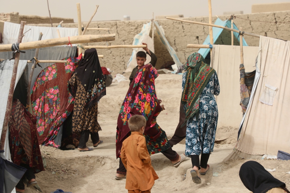Mujeres caminan entre tiendas de campaña provisionales en un campamento para personas desplazadas internas en la ciudad de Mazar-e Sharif, al norte de Afganistán.