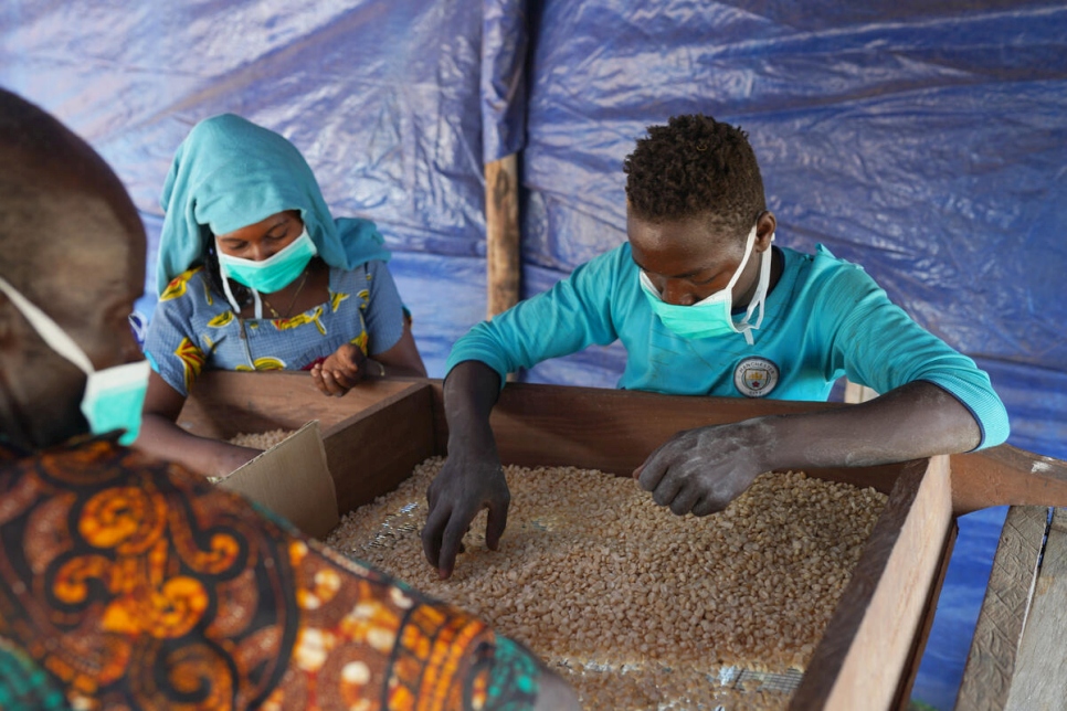 Granjeros locales y refugiados revisan maíz en el campamento de refugiados de Makpandu en Sudán del Sur (enero de 2021)