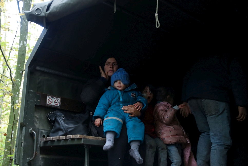 Una familia iraquí en un camión militar en Hajnowka, Polonia, tras cruzar la frontera desde Belarús el 14 de octubre de 2021. 