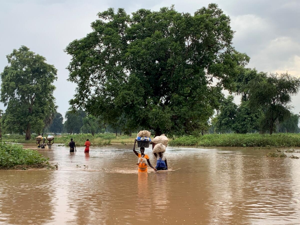 Familias atraviesan las aguas de la inundación en el estado del Alto Nilo, Sudán del Sur, en septiembre de 2021. 