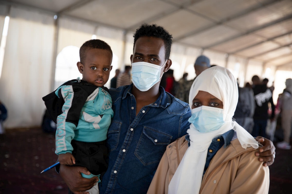 Abdsamad, un solicitante de asilo somalí, con su familia mientras esperan en el aeropuerto de Trípoli para abordar un vuelo a Roma.