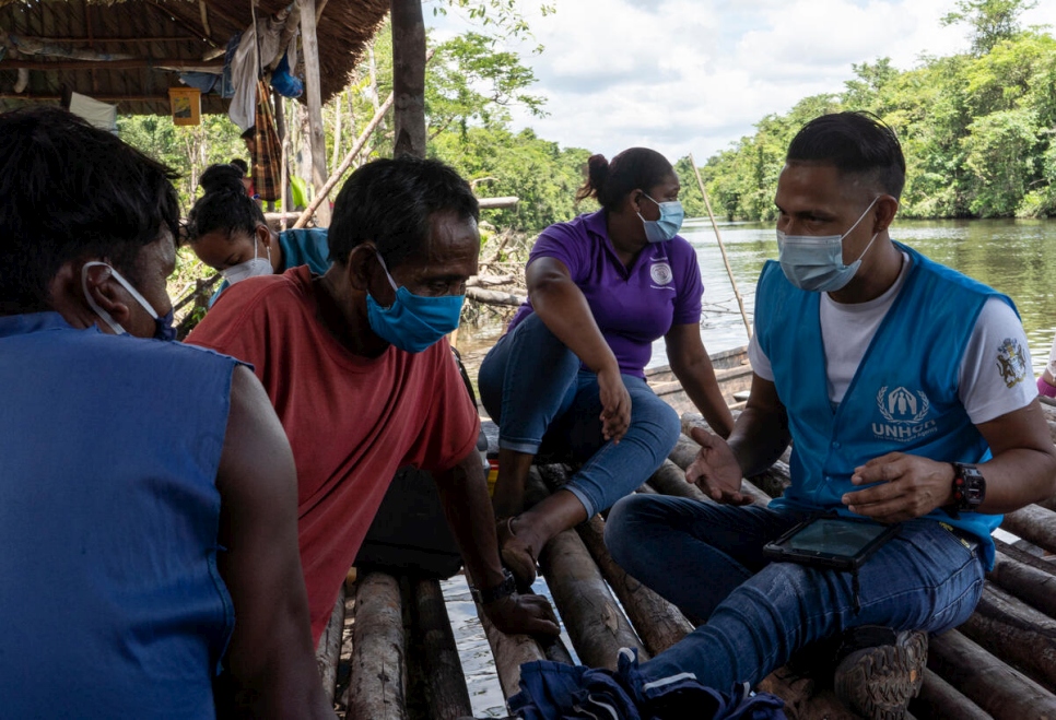 Alejandro y Katherine, de ACNUR, realizan un ejercicio de evaluación de las necesidades con familias venezolanas de la etnia warao que viven en un asentamiento informal a orillas del río. Muchas de sus necesidades incluyen la falta de acceso a alimentos, empleo y condiciones de salud.