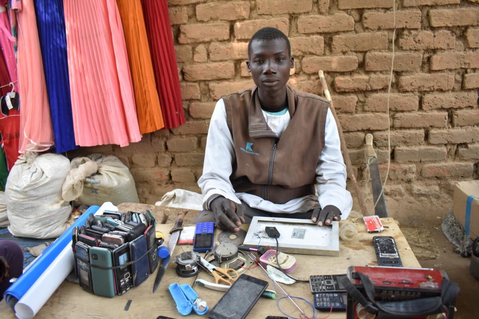 El refugiado camerunés Issa Hassane, de 25 años, gana dinero reparando teléfonos móviles en un lugar de acogida en Oundouma, Chad.