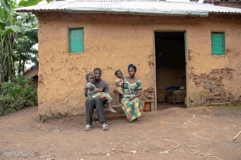 Obed*, de 25 años, quien recibió un disparo durante un ataque en 2020, se sienta con su familia afuera de su casa en Kibarizo.