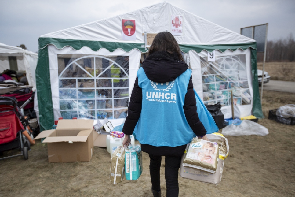 Trabajadora de ACNUR almacena pañales, alimentos, productos de higiene personal y otros artículos donados en el cruce fronterizo de Budomierz, en Polonia.