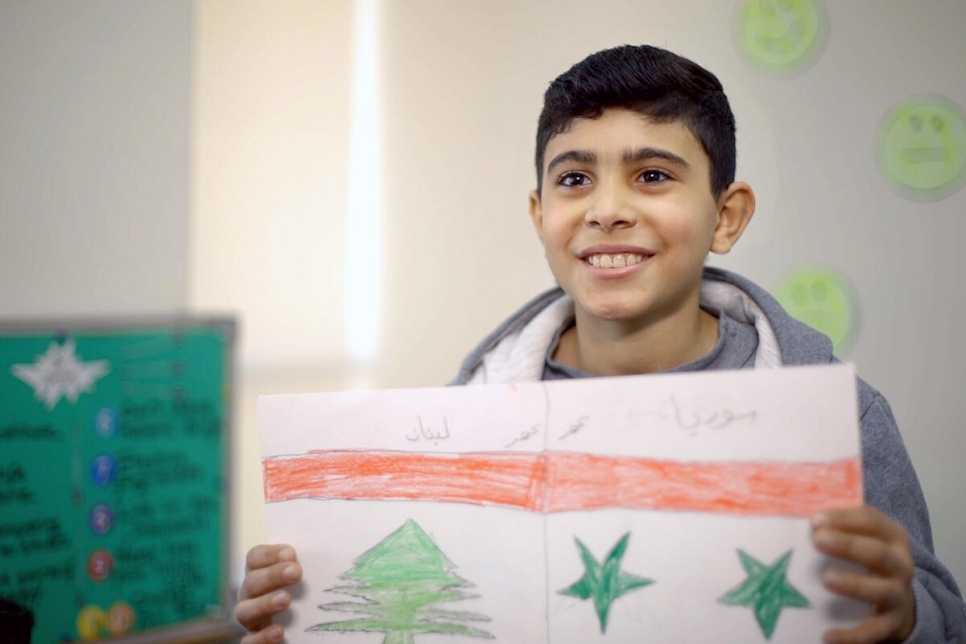 Omar, de 11 años, muestra su dibujo de las banderas libanesa y siria en un centro juvenil de Beirut, Líbano.
