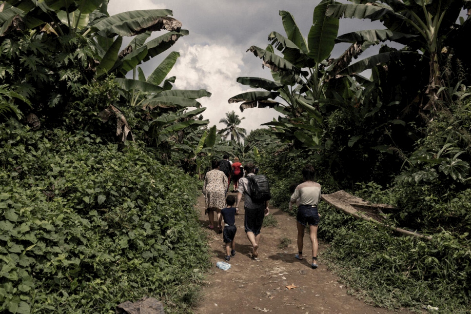Un grupo de personas refugiadas y migrantes camina hacia el pueblo de Canaan, en el extremo sur de Panamá, tras cruzar el Tapón de Darién.