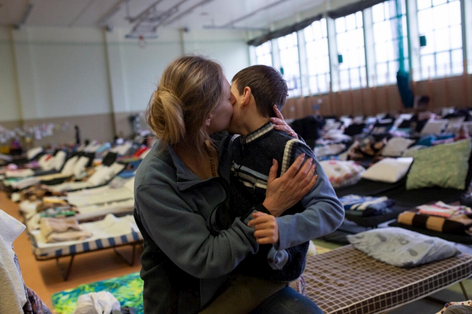 Una refugiada de Ucrania abraza a su hijo en un centro de acogida instalado en el pabellón deportivo de una escuela de la ciudad fronteriza polaca de Medyka.