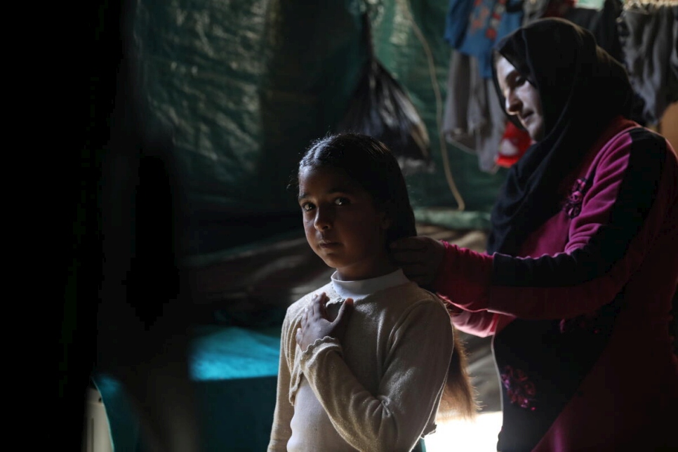 Asmaa cepilla el cabello de Arkan. La niña de 10 años se ha convertido en el principal sostén de la familia desde que su padre sufrió lesiones que le impiden trabajar.