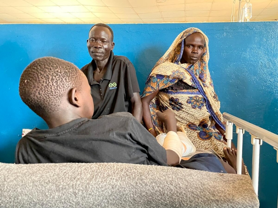Hissen Awad Mohammed (izquierda) y Haja Ibrahim observan a Fathihe, su hijo herido, en el hospital del condado de Maban, Bunj, Sudán del Sur.