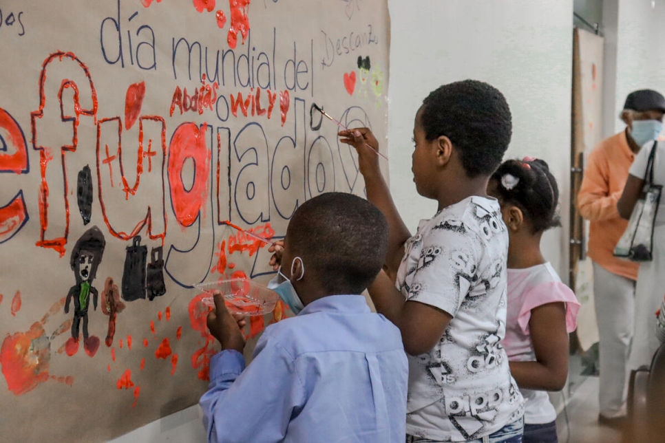 Descendientes de personas refugiadas de Haití pintan un mural durante la celebración del Día Mundial del Refugiado en República Dominicana.