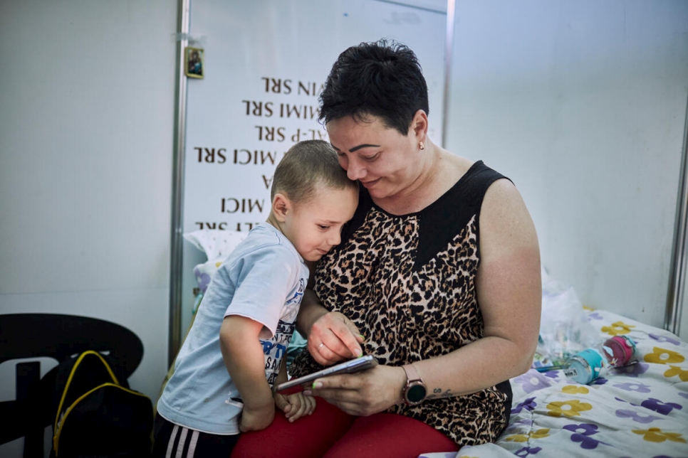Antonina* y su hijo Artem miran una foto familiar en su habitación de un centro de acogida para personas refugiadas en Chisinau, Moldavia. (*Antonia no participó en la encuesta de intenciones).


